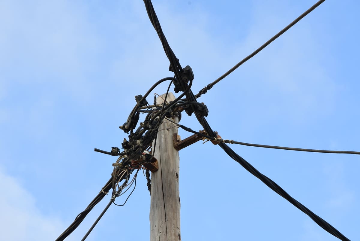 Freileitungen und Kabelverbindungen an einem Holzmast