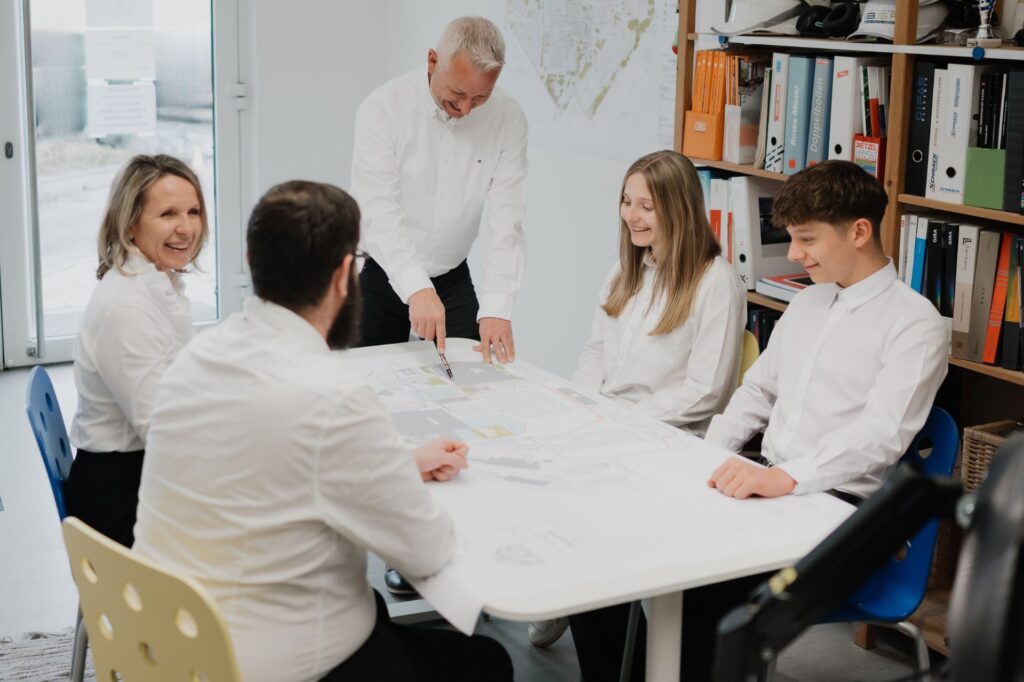 IBSR-Team bespricht gemeinsam einen Lageplan im Büro