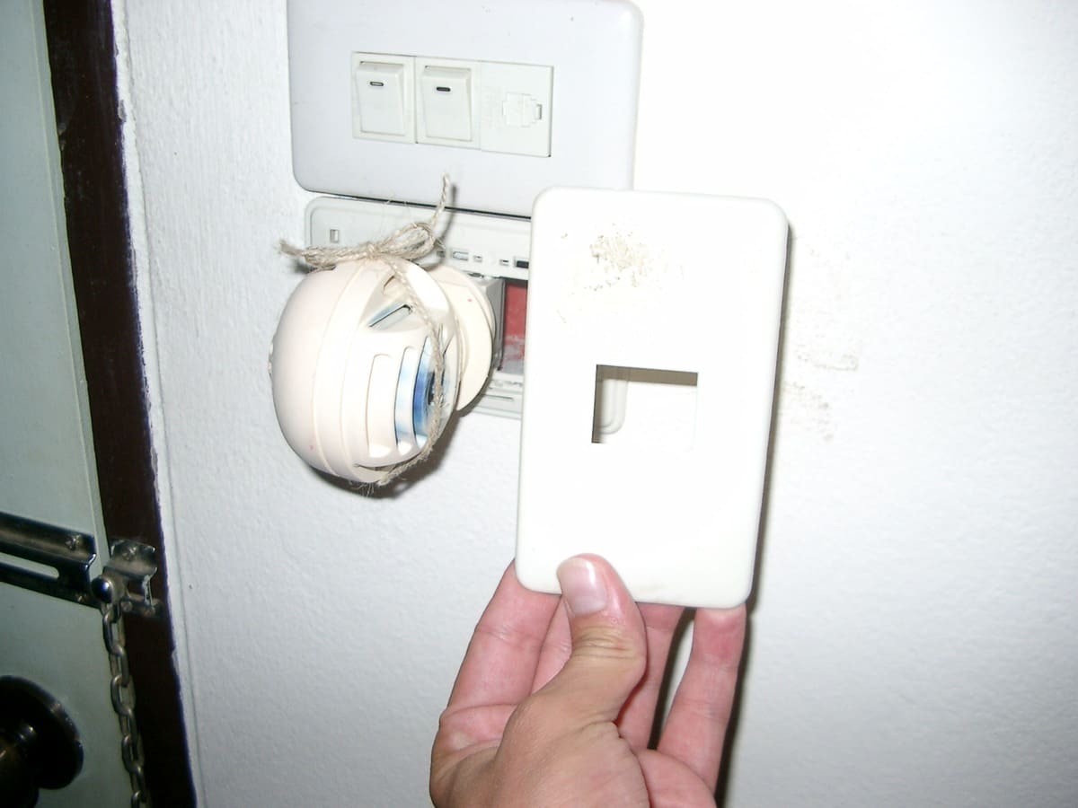 Geöffnete Abdeckung einer Wandinstallation mit frei liegenden Leitungen